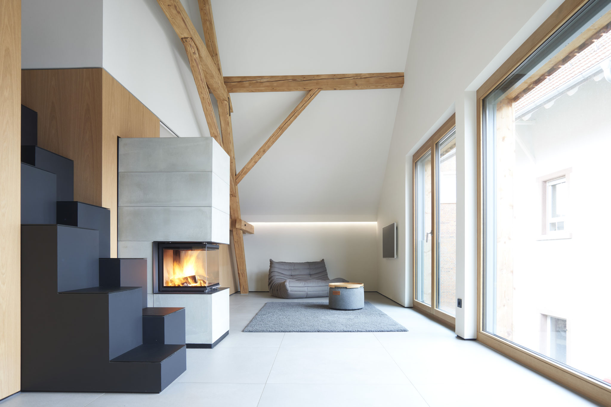 Ausgebautes Dachgeschoss mit Holzbalken, Kamin und Loungebereich