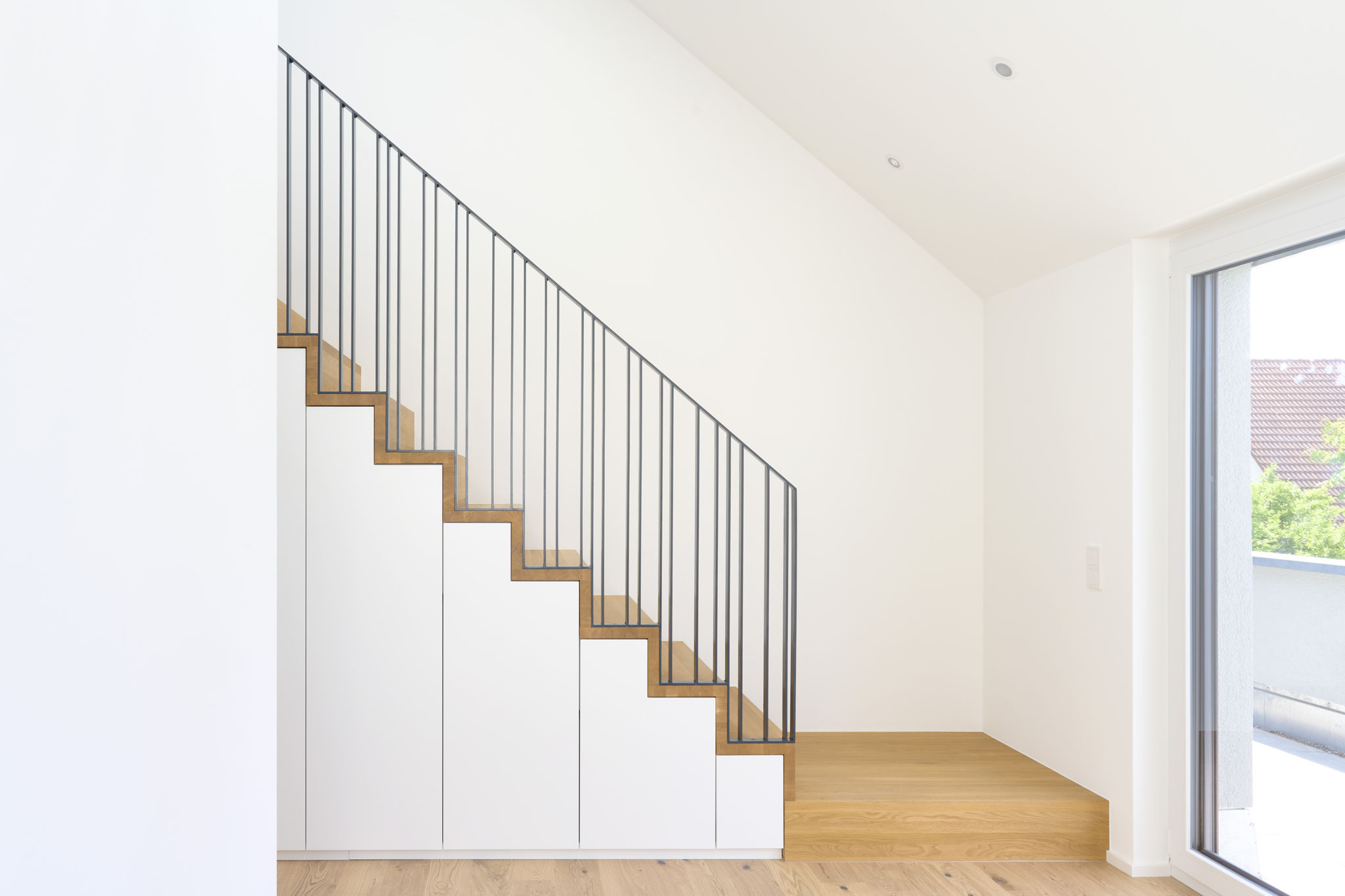 Maßgefertigte Treppe mit integriertem Stauraum und filigranem Stahlgeländer